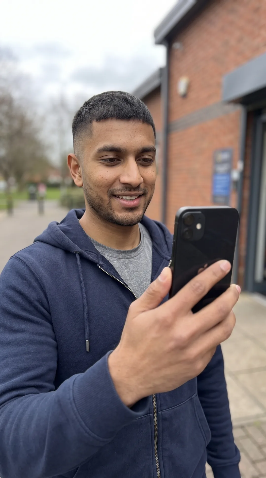Personal trainer taking a paid live check-in on his phone between sessions